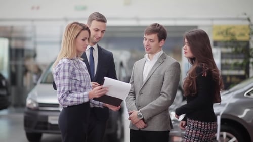 People Discussing Car Sales in Showroom