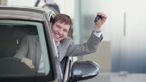 Young Man Celebrates New Car Purchase with Keys