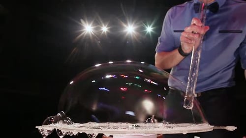 Man Creates Large Soap Bubble with Straw