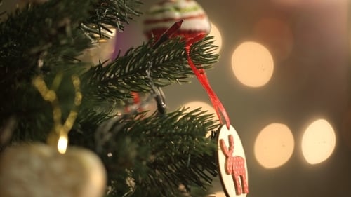 Hands Decorating Christmas Tree with Ornament Close Up