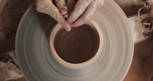 Potter Making Ceramic Pot on the Twisted Pottery Wheel. Top View. Potter at Work