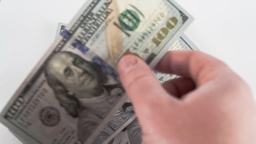 Counting Money on a White Surface