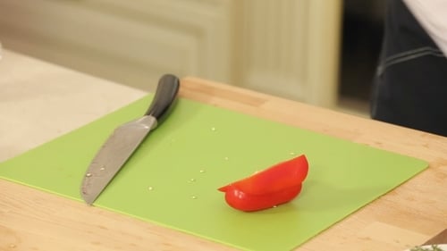 Chef Slices Red Pepper on Cutting Board