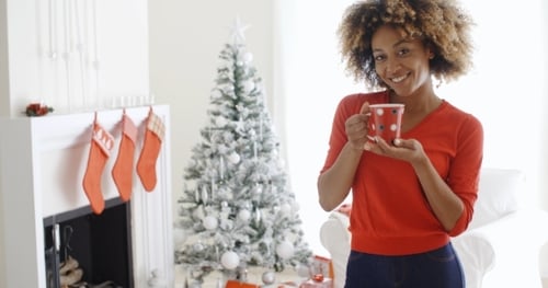Smiling Woman with Mug at Christmastime in Living Room