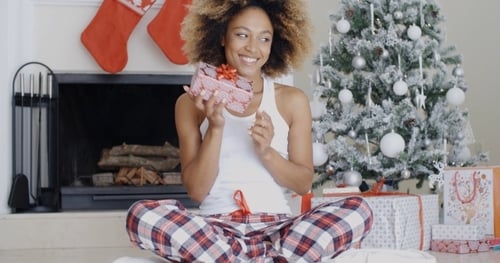 Woman Holding Christmas Gift Near Christmas Tree