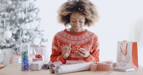 Woman Wrapping Christmas Present with a Smile