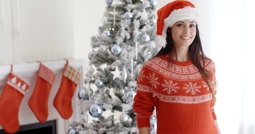 Festive Woman Smiling Near Christmas Tree and Stockings