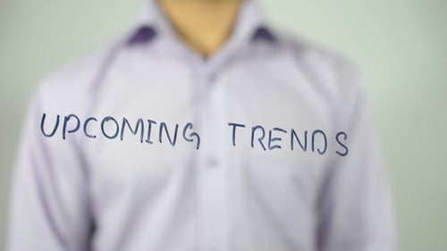 Man Writes 'Upcoming Trends' on Clear Surface