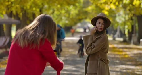 Woman Poses in Autumn Park for Photo