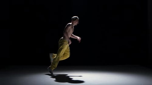 Breakdance Dancer Man in Yellow Suit with Naked Torso Continue Dance on Black, Shadow