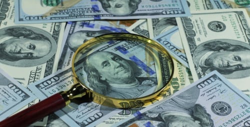 One Hundred Dollar Bills with Magnifying Glass