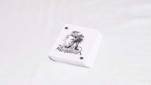 Black Joker Falls On Top Of a Pack Of Cards