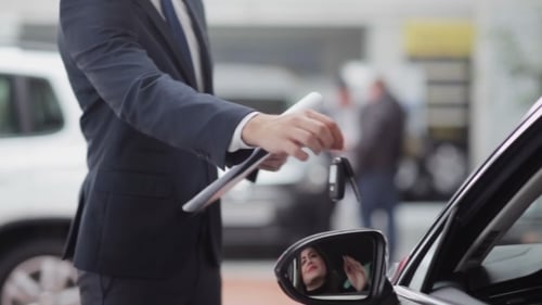 Vendedor entregando las llaves para un cliente feliz