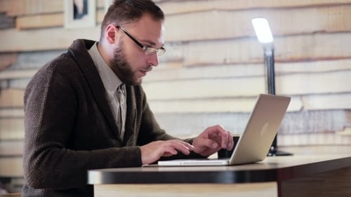 Man Typing on Laptop at Desk Indoors