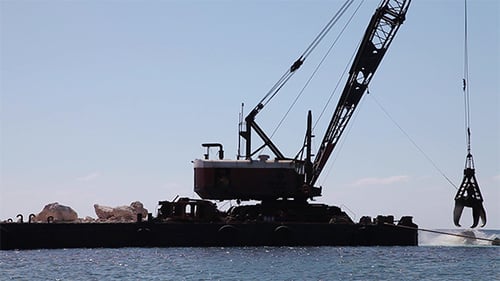 Crane At Work On a Stone Block Dam