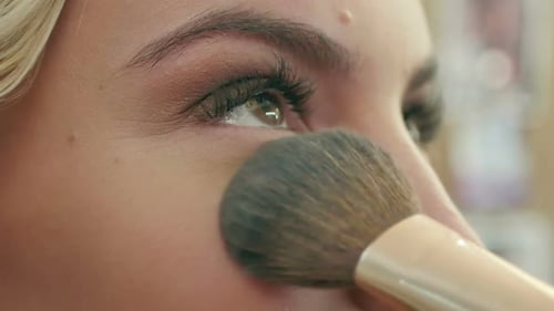 Close Up of Woman Applying Makeup with Brush