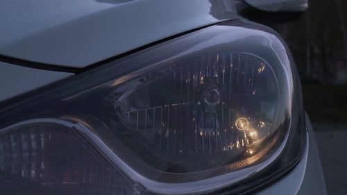 Close Up of Car Headlight Turning On at Night