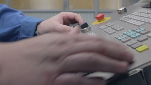 Hombre configura un panel de control de máquina industrial