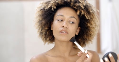 Woman Applies Flawless Makeup in Bright Indoor Setting