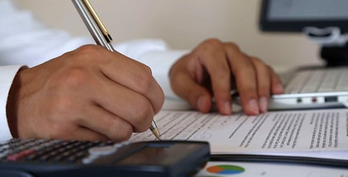 Adult Hands Writing with Pen in Office Setting
