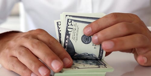 Person Counting Stack of Fifty Dollar Bills