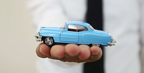 Man Holds Blue Antique Toy Car Model