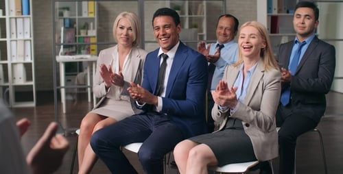 Diverse Team Listens and Applauds Presentation in Office