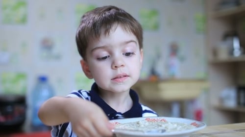 Young Boy Eating Cereal at Home
