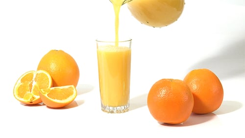 Fresh Orange Juice Pouring into Glass