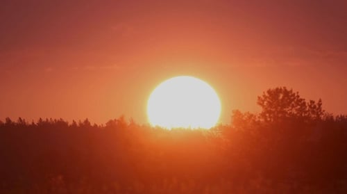 Fiery Sunrise Ascends with Golden Sky and Clouds