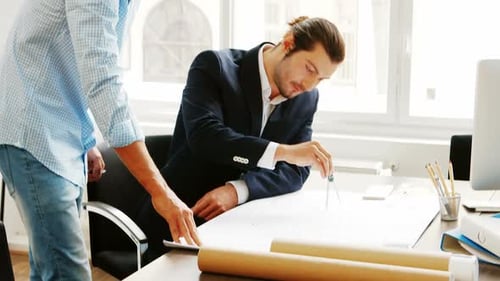 Architects Collaborating on Design Plans in Modern Office