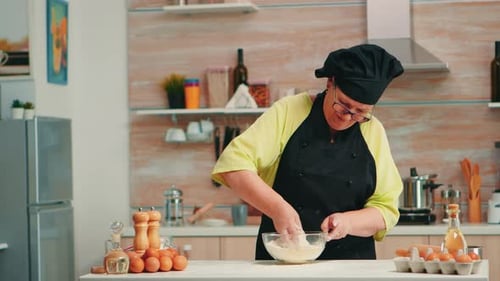 Adult Mixing Dough Ingredients with Hand in Kitchen