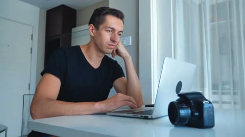 Young Adult Typing on Laptop at Home