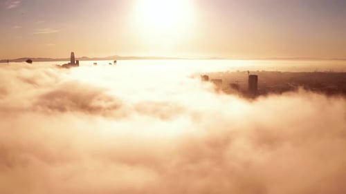 City Skyline Emerging from Cloud Cover at Sunrise