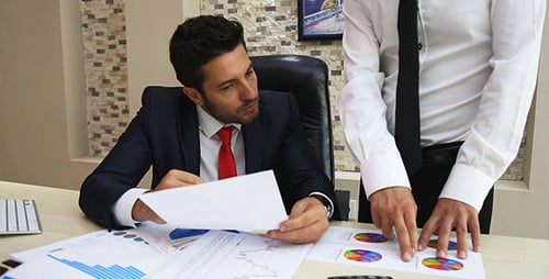 Businessmen Collaborating on Business Graphs and Charts