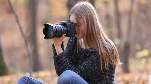 Woman Taking Pictures in the Autumn Forest
