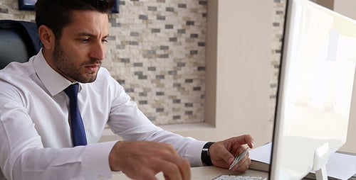 Man Typing at Computer with Credit Card