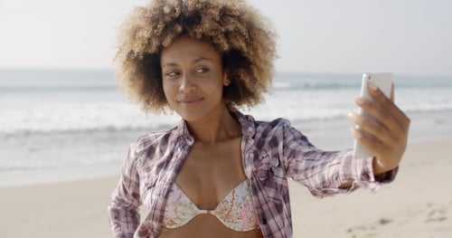 Woman Posing To Take A Selfie On The Beach
