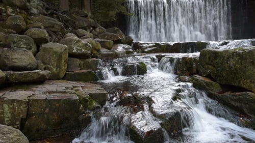 Beautiful Waterfall Flowing Over Rocks and Boulders