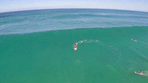 Aerial view of a man sup stand-up paddleboard surfing in Hawaii