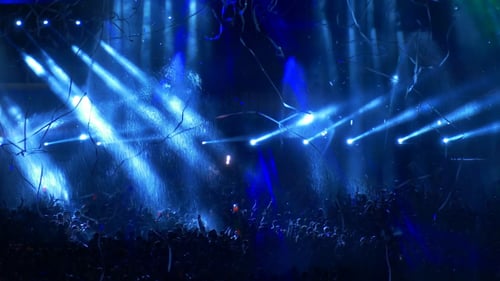 Huge crowd watching a music concert at night