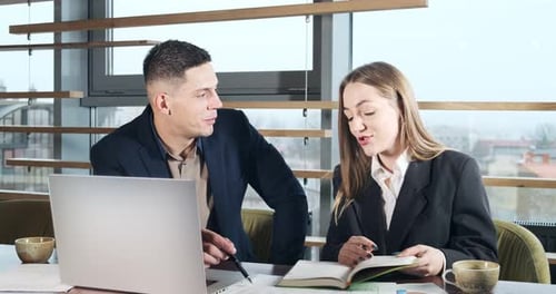 Man and a Woman Discussing Work in the Brightly Lit Modern Office. Concerned Male and Female Working