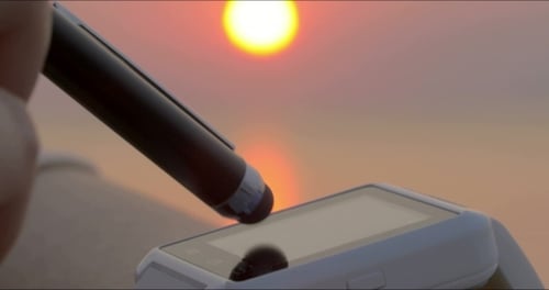 Smartwatch Being Operated With Stylus at Sunset