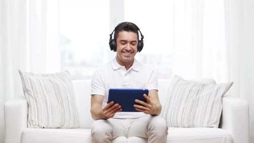Man Listening to Music on Tablet at Home