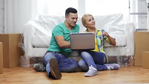 Couple Planning in New Home with Laptop