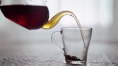 Tea Is Poured Into a Glass Cup