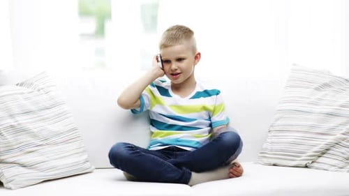 Boy Talking on Phone While Sitting on Couch