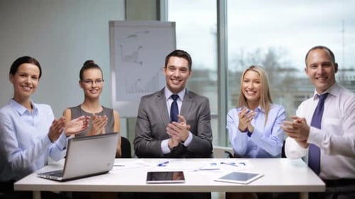 Smiling Business Team Clapping at a Meeting