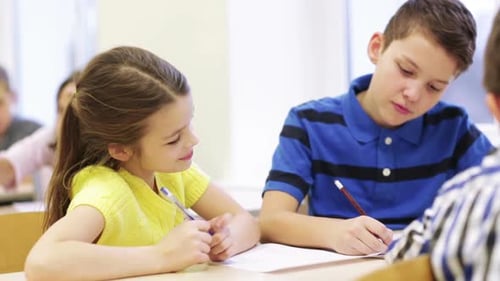 Group Of Students Talking And Writing At School