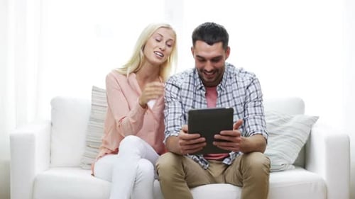 Couple Laughing Together Using Tablet at Home